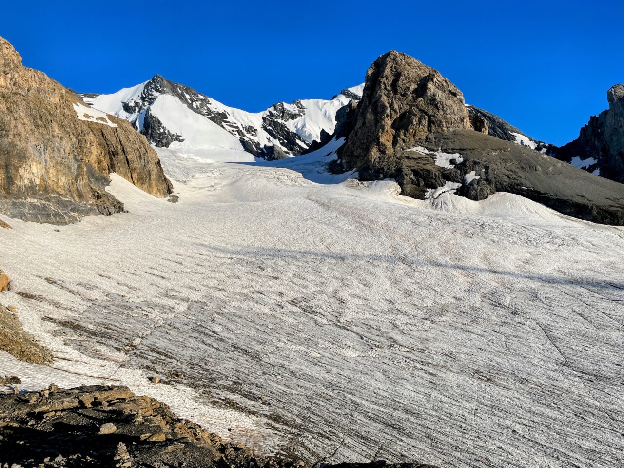 Auf der Hütte angekommen beziehen wir unser Zimmer (es hat mehrere Schlafsäle) und gönnen uns den obligatorischen Hüttenkuchen. Wir sind froh, dass wir die Etappe unterbrochen haben und heute nicht mehr absteigen müssen. Immer wieder schauen wir aus dem Fenster und plötzlich lichtet sich der Nebel und wir haben einen strahlend blauen Himmel vor uns - wow! Sofort werden die Schuhe nochmal angezogen und wir gehen los in Richtung Gletscher. Diesen haben wir nach ungefähr 10 Minuten erreicht und 2 aus unserer Gruppe sind zum ersten Mal auf einem Gletscher. Wir wagen uns ein paar Meter aufs Eis und hören dem Gluckern des Gletscherbaches zu.
