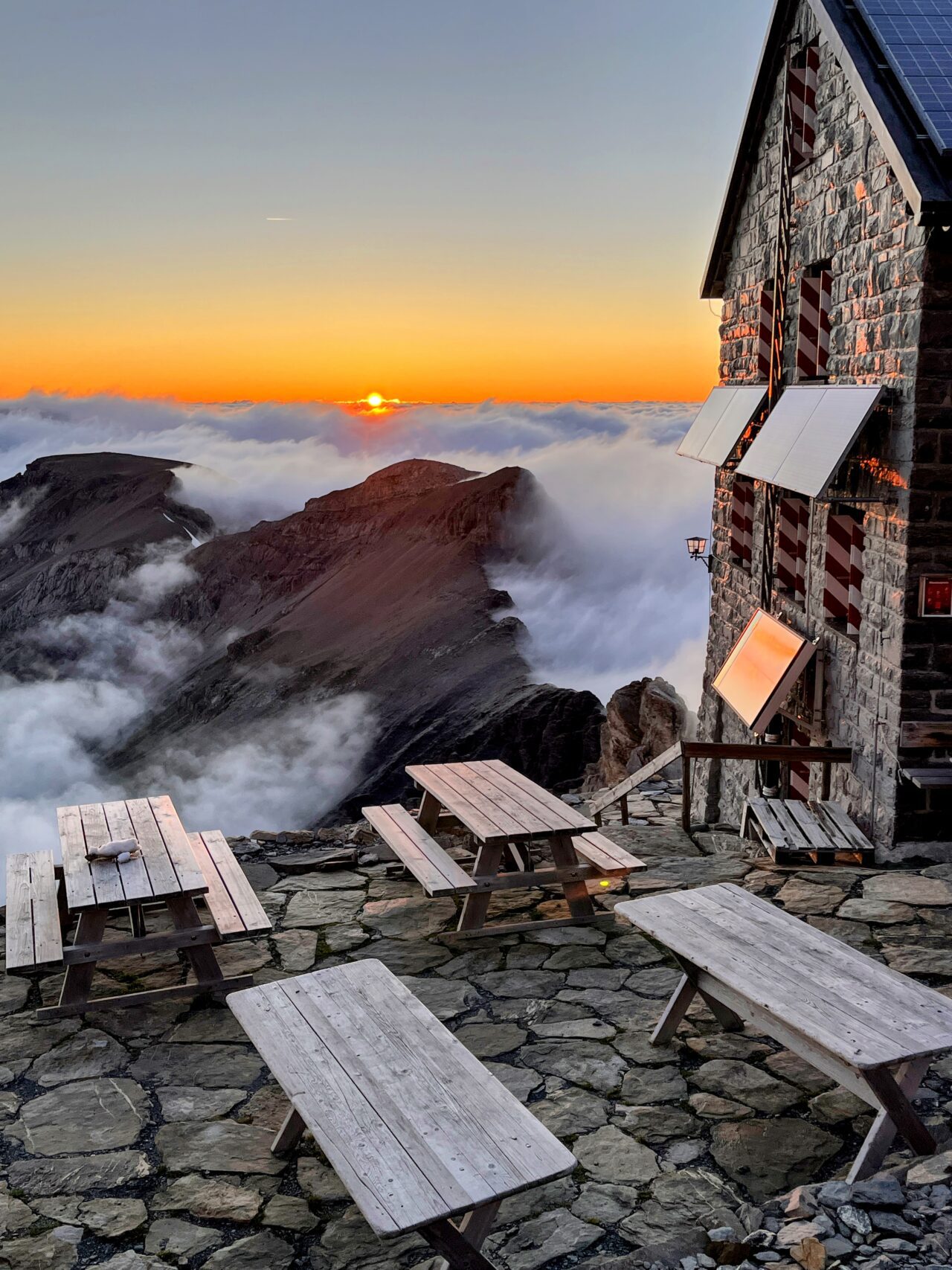 Auf der Hütte angekommen beziehen wir unser Zimmer (es hat mehrere Schlafsäle) und gönnen uns den obligatorischen Hüttenkuchen. Wir sind froh, dass wir die Etappe unterbrochen haben und heute nicht mehr absteigen müssen. Immer wieder schauen wir aus dem Fenster und plötzlich lichtet sich der Nebel und wir haben einen strahlend blauen Himmel vor uns - wow! Sofort werden die Schuhe nochmal angezogen und wir gehen los in Richtung Gletscher. Diesen haben wir nach ungefähr 10 Minuten erreicht und 2 aus unserer Gruppe sind zum ersten Mal auf einem Gletscher. Wir wagen uns ein paar Meter aufs Eis und hören dem Gluckern des Gletscherbaches zu.