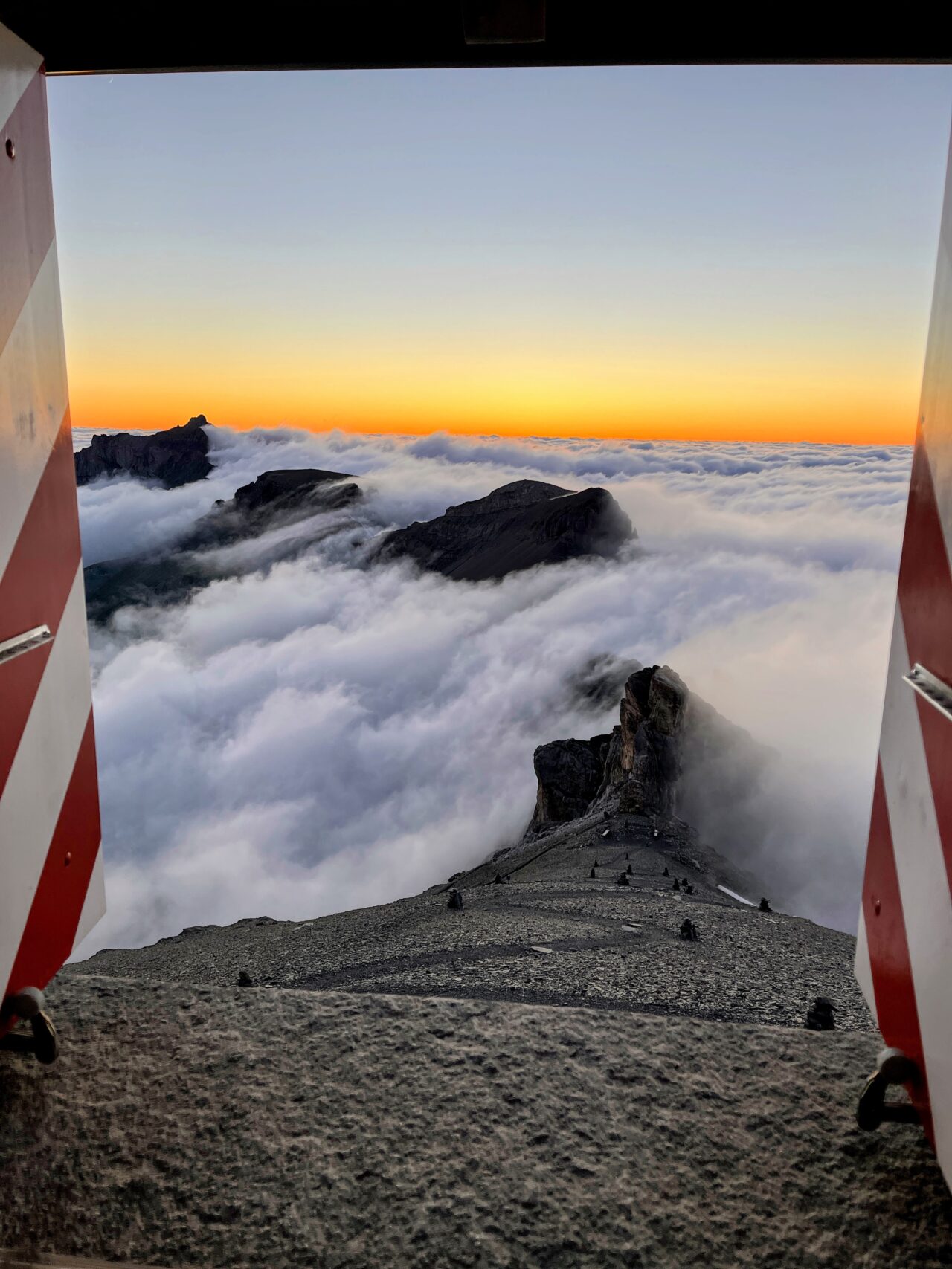 Auf der Hütte angekommen beziehen wir unser Zimmer (es hat mehrere Schlafsäle) und gönnen uns den obligatorischen Hüttenkuchen. Wir sind froh, dass wir die Etappe unterbrochen haben und heute nicht mehr absteigen müssen. Immer wieder schauen wir aus dem Fenster und plötzlich lichtet sich der Nebel und wir haben einen strahlend blauen Himmel vor uns - wow! Sofort werden die Schuhe nochmal angezogen und wir gehen los in Richtung Gletscher. Diesen haben wir nach ungefähr 10 Minuten erreicht und 2 aus unserer Gruppe sind zum ersten Mal auf einem Gletscher. Wir wagen uns ein paar Meter aufs Eis und hören dem Gluckern des Gletscherbaches zu.